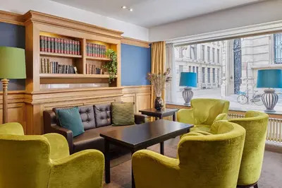a living room with green chairs and a table at Theater Hotel in Antwerp