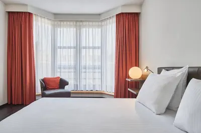 a bedroom with a bed and a chair and a window at Theater Hotel in Antwerp