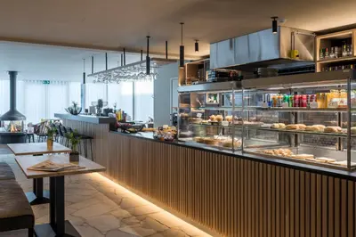 a restaurant with a counter with some food on it at PREMIER SUITES Antwerp in Antwerp