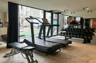 a gym with several tread machines in a room at PREMIER SUITES Antwerp in Antwerp