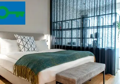 a bedroom with a bed and a large window at PREMIER SUITES Antwerp in Antwerp
