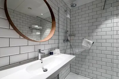a white bathroom with a sink and a mirror at PREMIER SUITES Antwerp in Antwerp