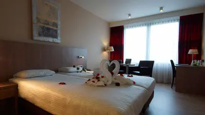 a hotel room with a bed with flowers on it at De Keyser Hotel in Antwerp