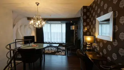 a living room with a table and a dining room at De Keyser Hotel in Antwerp