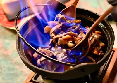 a pot of food is being stirred with wooden spoons at De Keyser Hotel in Antwerp