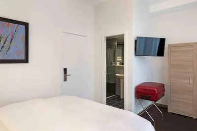 a bedroom with a bed and a television on a wall at Hôtel Argus by happyCulture in Brussels