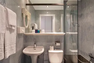 a bathroom with a sink and a toilet and a shower at Hôtel Argus by happyCulture in Brussels