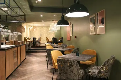 a restaurant with tables and chairs and a bar at Leonardo Hotel Antwerpen in Antwerp