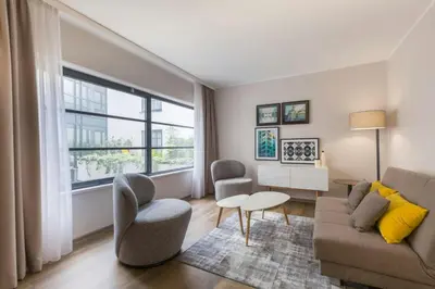 a living room with a couch and chairs and a table at Leonardo Hotel Antwerpen in Antwerp
