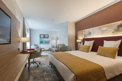 a hotel room with a large bed and a desk at Leonardo Hotel Antwerpen in Antwerp