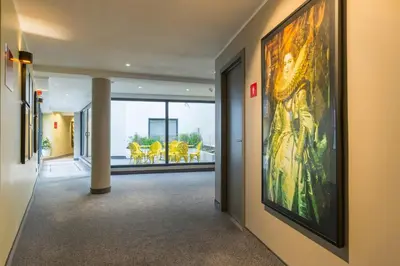 a hallway with a large painting on the wall at Leonardo Hotel Antwerpen in Antwerp