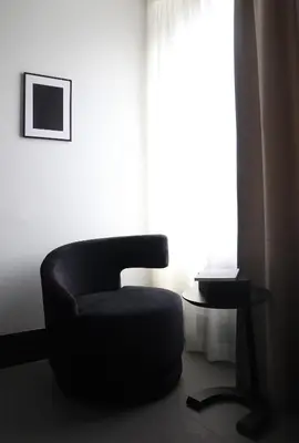 a black chair sitting in front of a window at Hotel National Antwerp in Antwerp