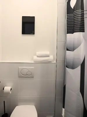 a bathroom with a toilet and a television at Hotel National Antwerp in Antwerp