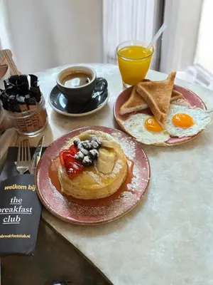 two plates of breakfast food on a table with eggs and toast at Hotel National Antwerp in Antwerp