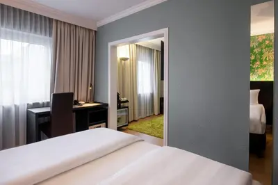 a hotel room with a bed and a desk and a mirror at Thon Hotel Brussels Airport in Diegem
