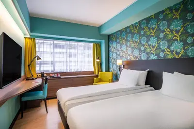 a hotel room with two beds and a desk and a tv at Thon Hotel Brussels City Centre in Brussels