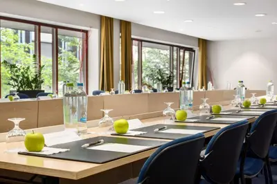 a conference room with a long table and chairs at NH Brussels Grand Place Arenberg in Brussels