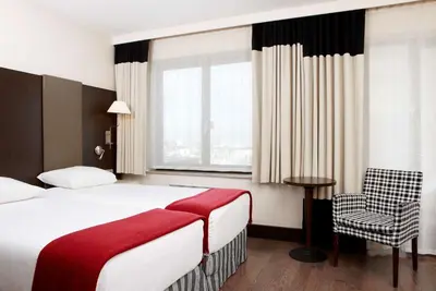 a hotel room with a bed and a chair at NH Brussels Grand Place Arenberg in Brussels