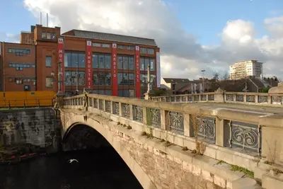 a bridge over a river with buildings in the background at Holiday Inn Gent Expo by IHG in Ghent