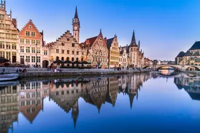 a city with a river with buildings and a clock tower at Holiday Inn Gent Expo by IHG in Ghent