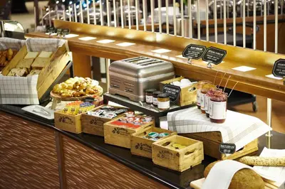 a bakery with a counter with food on it at Holiday Inn Gent Expo by IHG in Ghent