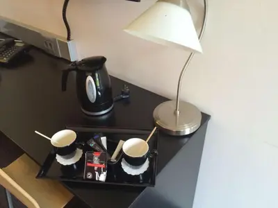 a table with two coffee cups and a lamp on it at Best Western Hotel Wavre in Wavre
