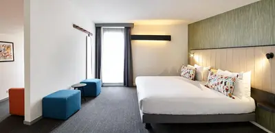 a hotel room with a bed and blue stool at Best Western Hotel Wavre in Wavre