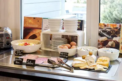 a counter with a microwave and a plate of food at Best Western Hotel Wavre in Wavre