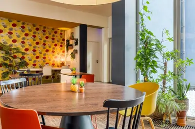 a dining room with a wooden table and chairs at Holiday Inn Express Mechelen City Centre by IHG in Mechelen