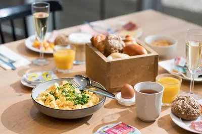 a table with a bowl of food and a box of donuts at Holiday Inn Express Mechelen City Centre by IHG in Mechelen
