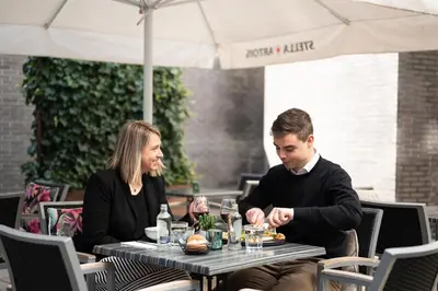 a man and woman sitting at a table in a restaurant at Holiday Inn Express Mechelen City Centre by IHG in Mechelen