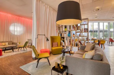 a living room with a couch and chairs at Holiday Inn Express Mechelen City Centre by IHG in Mechelen