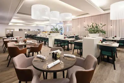 a dining room with tables and chairs and a restaurant at NH Collection Gent in Ghent