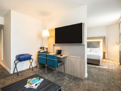 a hotel room with a desk and a bed at Novotel Brussels City Centre in Brussels