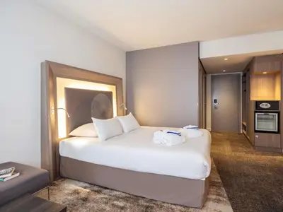 a bedroom with a large white bed with towels on it at Novotel Brussels City Centre in Brussels