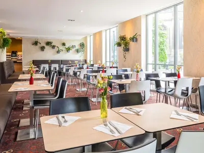 a dining room filled with tables and chairs at Novotel Brussels City Centre in Brussels