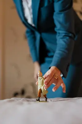 a person in a suit holding a toy figurine at Hotel Amigo, a Rocco Forte Hotel in Brussels