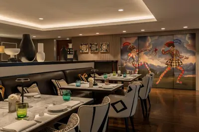 a restaurant with tables and chairs and a painting on the wall at Hotel Amigo, a Rocco Forte Hotel in Brussels