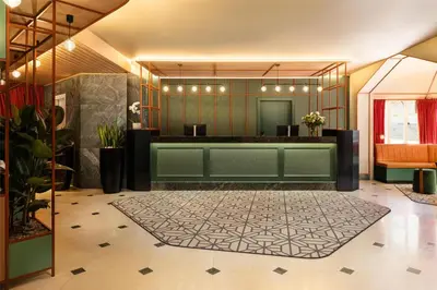 a lobby with a waiting area with green walls at NH Brussels Carrefour de L’Europe in Brussels