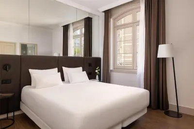 a large white bed in a room with a window at NH Brussels Carrefour de L’Europe in Brussels