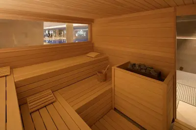 a wooden sauna with a tub and a window at Tangla Hotel Brussels in Brussels