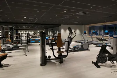 a gym with several treadmills and cardio machines at Tangla Hotel Brussels in Brussels