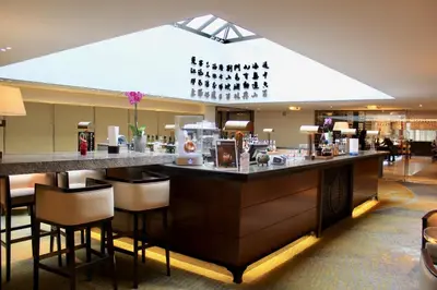 a bar in a hotel lobby with a bar counter at Tangla Hotel Brussels in Brussels