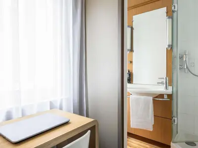 a bathroom with a sink and a laptop on a counter at Ibis Brussels City Centre in Brussels
