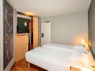 a hotel room with a bed and a tv at Ibis Brussels City Centre in Brussels