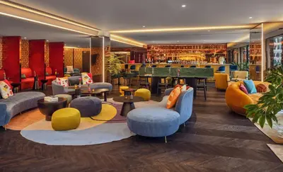 a restaurant with couches and tables and a bar at Cardo Brussels, Autograph Collection in Brussels