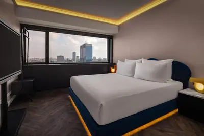 a bed in a room with a large window at Cardo Brussels, Autograph Collection in Brussels