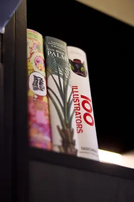three books on a shelf with a plant in the middle at Cardo Brussels, Autograph Collection in Brussels