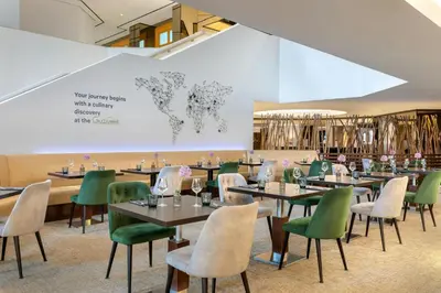 a restaurant with tables and chairs and a world map on the wall at Sheraton Brussels Airport Hotel in Zaventem