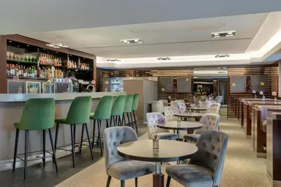 a restaurant with tables and chairs and a bar at Sheraton Brussels Airport Hotel in Zaventem